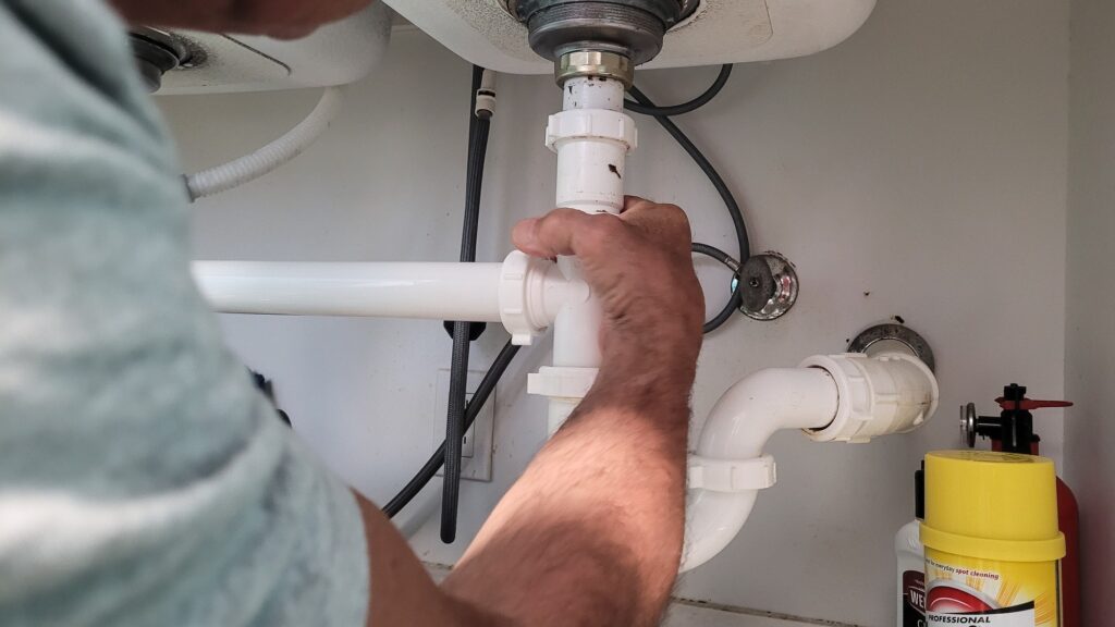 handyman-at-home-tightening-seals-on-plumbing-pipes-to-stop-a-leak-at-kitchen-sink-.jpg